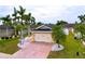 Charming home featuring lush landscaping, a brick driveway, and a two-car garage at 4826 San Ortebello Dr, Bradenton, FL 34208