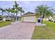 Charming home featuring a brick driveway, two-car garage, and tropical landscaping at 4826 San Ortebello Dr, Bradenton, FL 34208