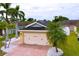 Home featuring a two-car garage, driveway, manicured lawn, landscaping with decorative stones and palm trees at 4826 San Ortebello Dr, Bradenton, FL 34208