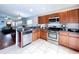 Kitchen with stainless steel appliances and wood cabinets offering views into the dining and living spaces at 4826 San Ortebello Dr, Bradenton, FL 34208