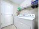Bright laundry room with washer, dryer, shelving, and a white door at 4826 San Ortebello Dr, Bradenton, FL 34208