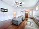 Spacious living room featuring hardwood floors, modern ceiling fan, TV, and comfortable leather seating at 4826 San Ortebello Dr, Bradenton, FL 34208