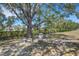 Tranquil backyard with shade trees, bench seating, and a well-maintained lawn at 4926 72Nd E St, Bradenton, FL 34203