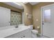 Bright bathroom features a white vanity, toilet, mirror and walk out access door at 4926 72Nd E St, Bradenton, FL 34203