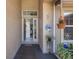 Inviting front entry featuring a decorative welcome sign, hanging flower pots, and an open glass door at 4926 72Nd E St, Bradenton, FL 34203