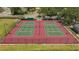 Aerial view of two fenced in tennis courts at Creekwood Lakeside with red and green court colors at 4926 72Nd E St, Bradenton, FL 34203