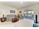 Comfortable living room with neutral carpet, sliding glass doors to a screened patio, and serene water views at 5102 98Th E Ave, Parrish, FL 34219