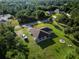 Aerial view of the home and lush yard surrounded by mature trees showcasing the property's appeal at 5955 Ferendina St, North Port, FL 34291