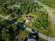 Aerial view showcases the home's location within a mature wooded neighborhood, offering a serene and private setting at 5955 Ferendina St, North Port, FL 34291