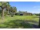 Huge, grassy backyard with mature palm trees, an outdoor grill, and space to relax at 5955 Ferendina St, North Port, FL 34291