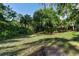 Lush backyard with mature trees provides a secluded and private outdoor space at 5955 Ferendina St, North Port, FL 34291