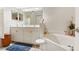 This luxurious bathroom features double sinks, a soaking tub, and ample storage at 5955 Ferendina St, North Port, FL 34291