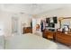 This primary bedroom has wood furniture, ceiling fan and TV, along with a doorway to the ensuite bathroom at 5955 Ferendina St, North Port, FL 34291