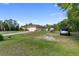 Spacious home exterior featuring a long driveway, lush lawn, and mature trees in a serene setting at 5955 Ferendina St, North Port, FL 34291