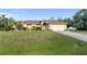 Well-maintained home with mature landscaping, a two-car garage, and a spacious front yard at 5955 Ferendina St, North Port, FL 34291