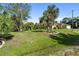 Sprawling front yard with mature trees and landscaping offers curb appeal and a park-like setting at 5955 Ferendina St, North Port, FL 34291
