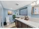 Bright blue bathroom with modern fixtures, spacious vanity, decorative wall art, and window for natural light at 6013 Murdock Ave, Sarasota, FL 34231