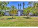 Charming home with lush green lawn, swaying palms, and a freshly painted exterior on a sunny day at 6013 Murdock Ave, Sarasota, FL 34231
