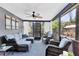 Inviting patio with comfortable wicker furniture, sheer curtains, and a ceiling fan, perfect for relaxing and enjoying the outdoors at 6013 Murdock Ave, Sarasota, FL 34231