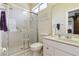 Bright bathroom with glass shower doors, white vanity, and updated fixtures at 6110 Misty Oaks St, Sarasota, FL 34243