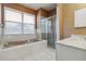 Bathroom featuring a walk in shower, soaking tub, white vanity and a large window at 6110 Misty Oaks St, Sarasota, FL 34243