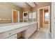 Bathroom with white dual sink vanity, walk in shower, soaking tub and natural wall coverings at 6110 Misty Oaks St, Sarasota, FL 34243