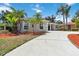 Single story house with a well-maintained lawn and a long driveway at 6110 Misty Oaks St, Sarasota, FL 34243