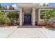 Inviting front entrance with a double blue door, pillars, and mature landscaping adds to the curb appeal of this lovely home at 6110 Misty Oaks St, Sarasota, FL 34243