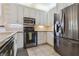 Modern kitchen with stainless steel appliances, white cabinets and a neutral tile flooring at 6110 Misty Oaks St, Sarasota, FL 34243