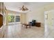Open concept living room with neutral paint, tile floors, ceiling fan, and views of the pool at 6110 Misty Oaks St, Sarasota, FL 34243