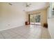Large living room features sliding glass doors to the pool, tile flooring and a fan at 6110 Misty Oaks St, Sarasota, FL 34243