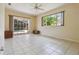 Spacious living room with tile floors, fan, large window and a sliding glass door to the pool at 6110 Misty Oaks St, Sarasota, FL 34243