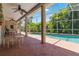 Covered patio with screened-in pool, ceiling fans, and seating area at 6110 Misty Oaks St, Sarasota, FL 34243