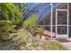 A screened-in pool sits next to the house with potted plants and a patio at 6110 Misty Oaks St, Sarasota, FL 34243