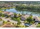 Aerial view of a beautiful home near a lake, surrounded by lush greenery and palm trees at 6520 38Th E Ln, Sarasota, FL 34243
