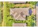 Aerial view of a home with a well-maintained roof, landscaping, and surrounding palm trees at 6520 38Th E Ln, Sarasota, FL 34243