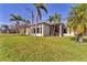 Lush backyard with palm trees and manicured lawn surrounding the home at 6520 38Th E Ln, Sarasota, FL 34243