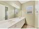 Bright bathroom featuring double sinks, large mirror, and a window for natural light at 6520 38Th E Ln, Sarasota, FL 34243