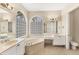 Bright bathroom features a soaking tub under large windows, double vanities, and a toilet room at 6520 38Th E Ln, Sarasota, FL 34243