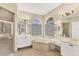 Bright bathroom features a soaking tub under large windows, double vanities, and a glass enclosed shower at 6520 38Th E Ln, Sarasota, FL 34243