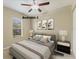A spacious, staged bedroom with a ceiling fan, a plush bed, and soft, neutral colors at 6520 38Th E Ln, Sarasota, FL 34243