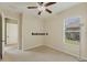 Carpeted bedroom with a ceiling fan and a large window for natural light at 6520 38Th E Ln, Sarasota, FL 34243