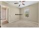 An empty bedroom with a ceiling fan, neutral colors, and a large window at 6520 38Th E Ln, Sarasota, FL 34243