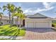 Lovely single-story home with brick driveway and well-manicured lawn lined with mature palm trees at 6520 38Th E Ln, Sarasota, FL 34243