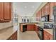 Well-equipped kitchen featuring black appliances, light countertops, and wood cabinetry at 6520 38Th E Ln, Sarasota, FL 34243