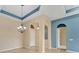 Bright living room featuring arched doorways, neutral paint, and a modern chandelier at 6520 38Th E Ln, Sarasota, FL 34243