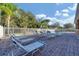 Community pool with lounge chairs and well-maintained brick patio area, perfect for relaxation at 6520 38Th E Ln, Sarasota, FL 34243