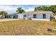 A single-story home with a tidy lawn and attached garage, set against a backdrop of lush greenery at 6611 2Nd Ne Ave, Bradenton, FL 34208