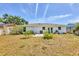 Exterior view of the home's rear with a concrete patio and a spacious backyard at 6611 2Nd Ne Ave, Bradenton, FL 34208