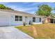 A quaint home with a brick path leading to the front door and a well-manicured lawn and an attached garage at 6611 2Nd Ne Ave, Bradenton, FL 34208